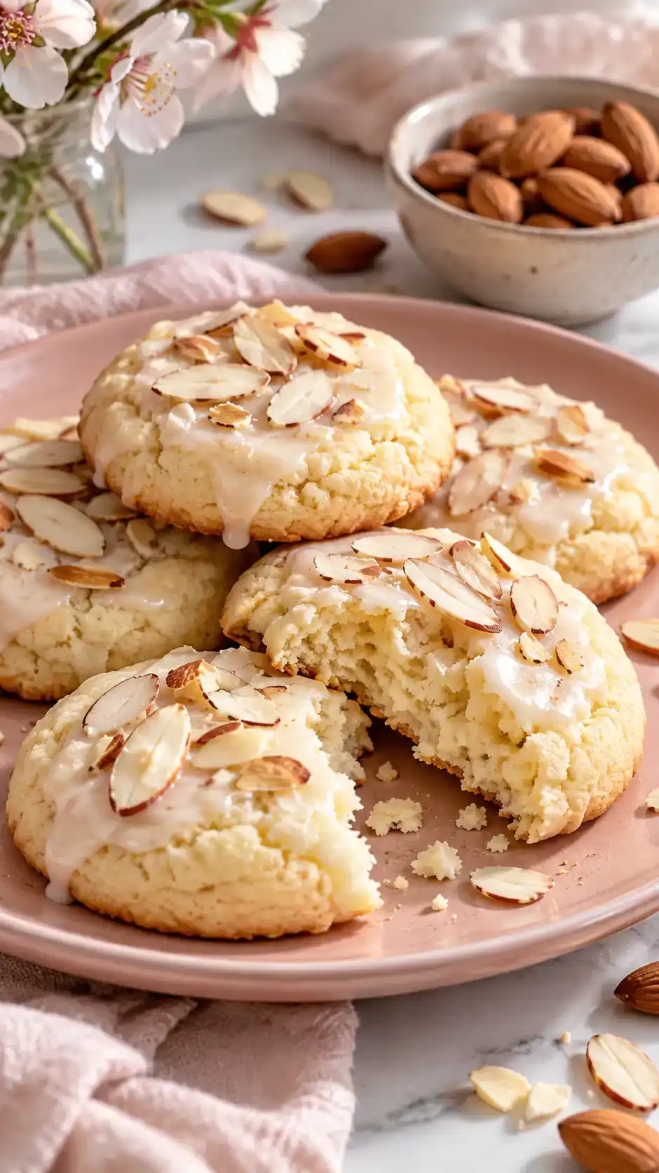 Soft almond sugar cookies with a light almond glaze and optional sliced almonds over gently golden edges.