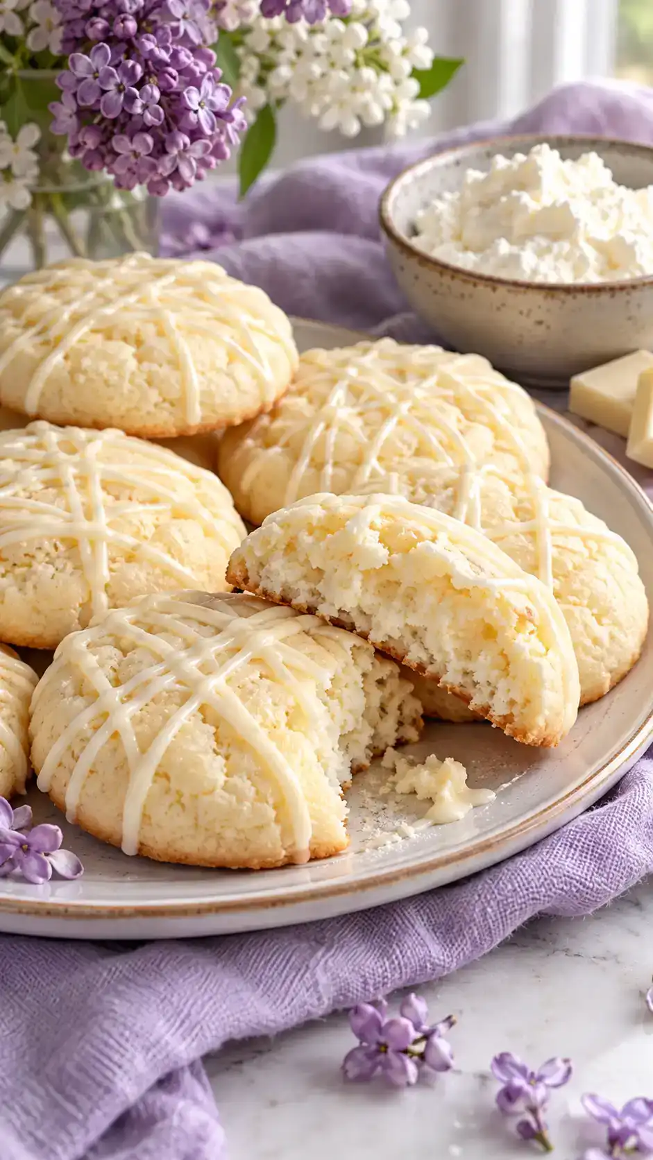 Soft ricotta sugar-cookie rounds with a moist fine crumb and a delicate white-chocolate drizzle.